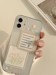 a person holding a cell phone case with flowers on the back and a note attached to it