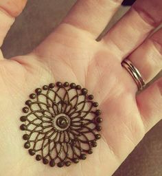 a woman's hand with a ring on it that has an intricate design in the middle