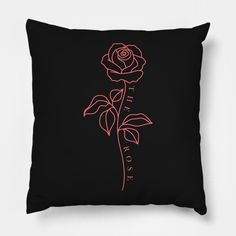 a black pillow with a pink rose on it