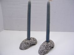 there are two candles that have been made out of rock and one is shaped like an elephant's foot