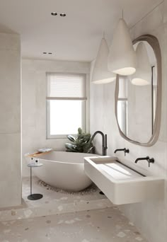 a white bathtub sitting next to a sink in a bathroom under a large mirror