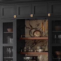 a kitchen with black cabinets and marble counter tops, gold trim on the doors is shown