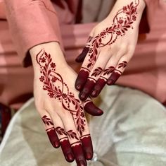 a woman's hands with henna tattoos on them