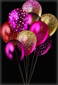 a bunch of balloons that are in the shape of hearts on a black background with gold and pink confetti