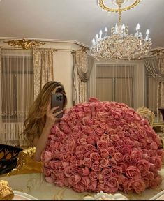 a woman taking a selfie in front of a large bouquet of roses