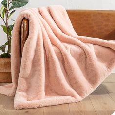 a pink blanket sitting on top of a wooden chair