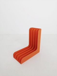 an orange chair sitting on top of a white floor