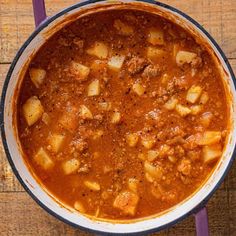 a pot filled with stew sitting on top of a wooden table