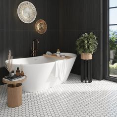 a bath tub sitting next to a window in a room with black walls and flooring