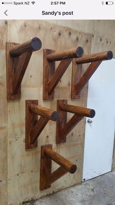 three wooden brackets are mounted on the side of a wall with nails attached to them