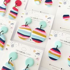 some colorful buttons are laying next to each other on white cards with different designs and colors