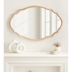 a white mantle with a mirror and vase on it