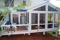 a white house with screened porch and deck