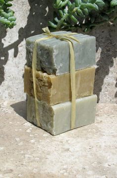 a stack of soaps wrapped in yellow ribbon sitting on top of a stone slab