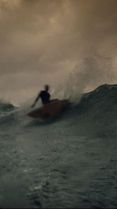 a man riding a wave on top of a surfboard in the middle of the ocean