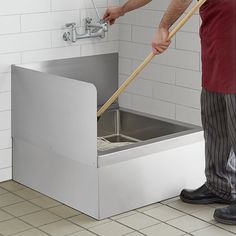 a man is cleaning the floor with a plunger and mop in his hand