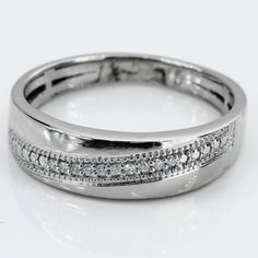 a close up view of a wedding ring with diamonds on the sides and in the middle