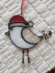 a glass ornament with a bird wearing a santa hat