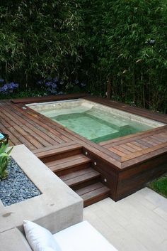 an outdoor hot tub in the middle of a garden