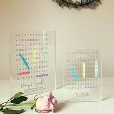 two clear acrylic blocks with words on them and a pink rose next to it