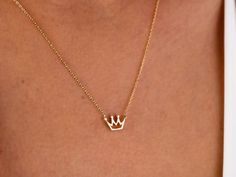 "The 14K Gold Crown Necklace is a delicate and dainty piece of jewelry that is perfect for any princess in your life. It features a tiny solid gold crown pendant that is delicate and feminine, making it a perfect choice for those who prefer subtle and understated jewelry. This necklace is made from 14K gold, which is a high-quality and valuable metal that is resistant to tarnish and wear. It is the perfect gift for any special occasion, whether it be for Christmas, Father's Day, Mother's Day, Va 14k Gold Crown Design Jewelry As A Gift, Dainty Jewelry With Crown Design For Gift, 14k Gold Jewelry With Crown Design For Gift, Dainty Jewelry With Crown Design As Gift, Crown Jewellery, Understated Jewelry, Crown Pendant Necklace, Mini Crown, Crown Pendant