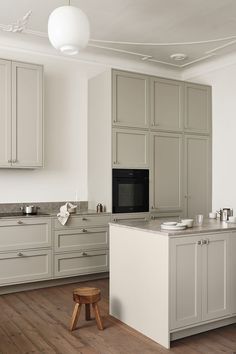 a kitchen with white cabinets and wooden floors