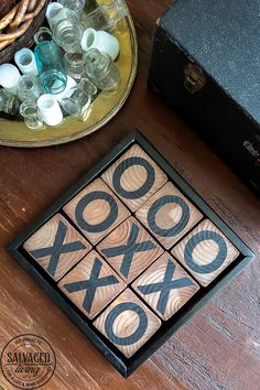 a wooden tic - tac toe game sitting on top of a table next to an old suitcase