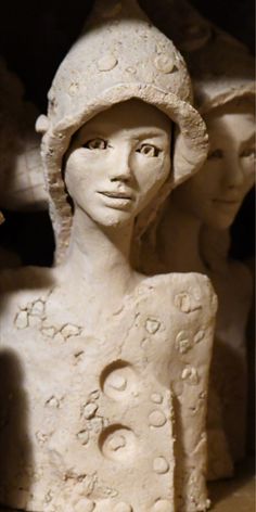 a sculpture of a woman wearing a hat