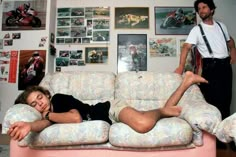 a man laying on top of a couch next to a woman