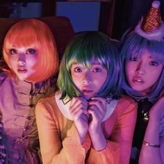 three young women with bright colored hair are posing for the camera