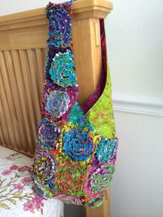 a multicolored bag hanging from a wooden headboard