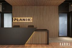 an office with wooden paneling and black desk in front of a sign that reads plank