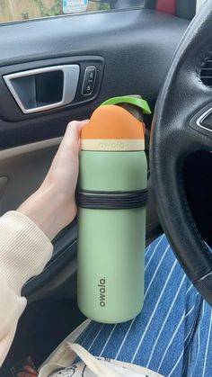 a person is holding an orange in their car