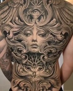 the back of a man with tattoos on his body and head, surrounded by intricate designs