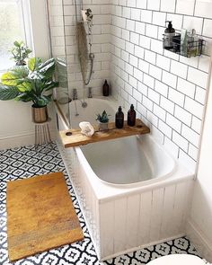 a white bathroom with black and white tile flooring, a bathtub in the middle