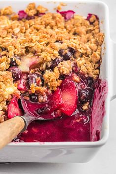 a close up of a dish of food with fruit and crumbled toppings