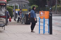 a woman standing next to a bus stop