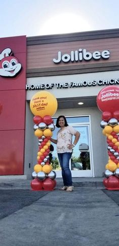 a woman standing in front of a home of the famous chickbob balloon arch