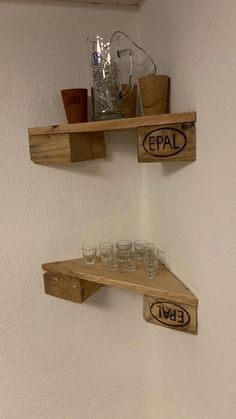 two wooden shelves with wine glasses and cups on them, one shelf is made out of pallets