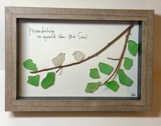 two birds sitting on a branch with green leaves in a shadow box that says, friends is good for the soul