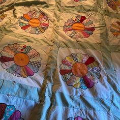 two quilts with flowers on them are laying on a bed sheet that is made to look like an elephant