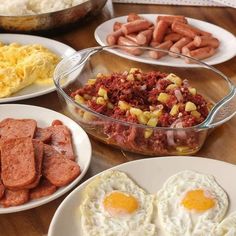 several plates of food on a table with eggs, sausages and hashbrowns