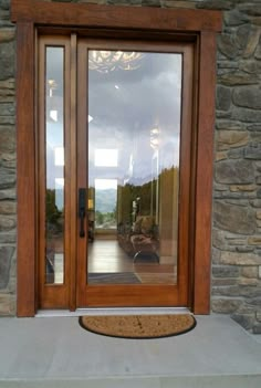 the front door to a home with glass and wood