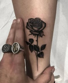 a woman's arm with a rose tattoo on the left side of her leg