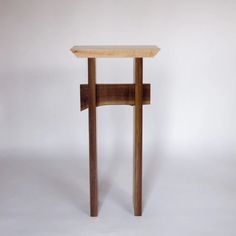 a small wooden table sitting on top of a white floor