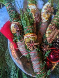 christmas decorations wrapped in twine and tied with red ribbon on a silver platter