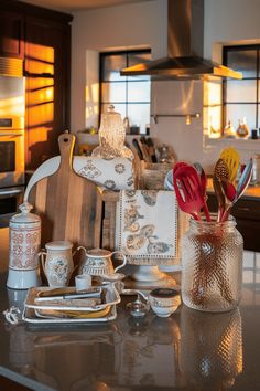 a kitchen counter with dishes and utensils in a glass jar on top of it