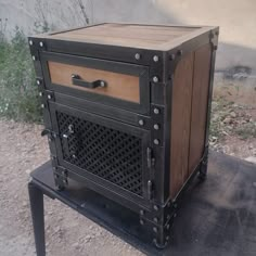 an old fashioned wood and metal cabinet sitting on top of a table