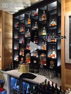 there are many bottles on the shelves behind the bar