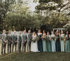 a group of people standing next to each other on top of a grass covered field